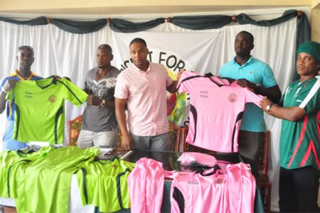 The organising committee for the “Cricket for Unity” match handing over uniforms to their two coaches.