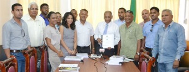 Agriculture Minister, Dr Leslie Ramsammy (centre) along with representatives of the National Drainage and Irrigation Authority and the recipients of the contracts. (GINA photo) 