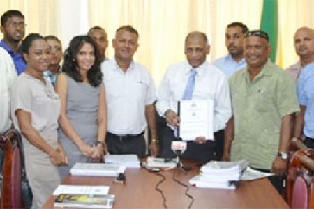 Agriculture Minister, Dr Leslie Ramsammy (centre) along with representatives of the National Drainage and Irrigation Authority and the recipients of the contracts. (GINA photo)
