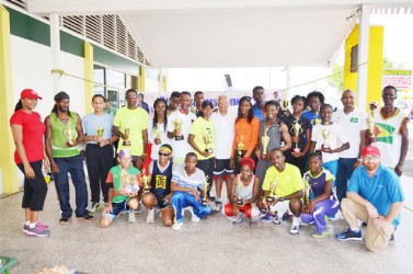 Neal and Massy Group of Companies, CEO Deo Persaud, poses with the winners of the fourth Annual NM 10 Km athletic road race yesterday. 