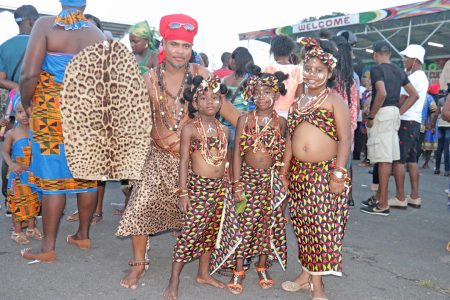 Looks like a Zulu warrior at left with these gaily outfitted girls.