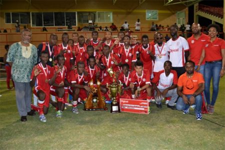 Prime Minister Samuel Hinds (left) posing with the Wismar-Christianburg team, the now three-time winners of the Digicel Schools Football Tournament yesterday. (GINA photo)