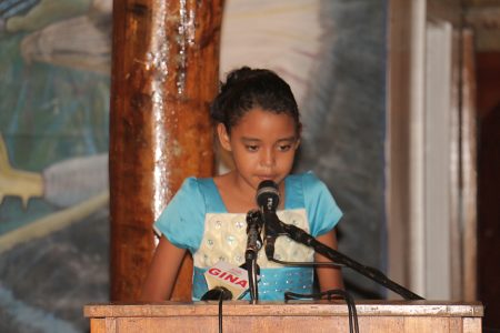 A girl recites a children’s poem on Friday at the Umana Yana. Twenty Five Poems by Guyanese Children, an anthology edited by Rev. Gideon Cecil, was among the 15 new Guyana Classics titles launched by the Caribbean Press. (Photo by Arian Browne)