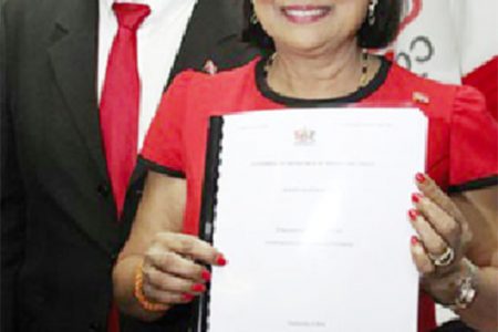 Prime Minister Kamla Persad-Bissessar with a copy of the 2014-2015 budget statement at COP’s eighth anniversary and interfaith service, Rooftop Plaza De Montrose in Chaguanas on Saturday. 