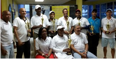 In picture with trophies from left to right back row Pur Persaud, Mohanlall Dinanauth, Rishi Sukhram, Patrick Prashad, Mahendra Bhagwandin, Avinda Kishore and Ian Gouveia. Seated with trophy Juliet Prince, without trophy Courts representative, Kenneth Scrub, standing and Roberta Ferguson and Clyde De Haas sitting. 