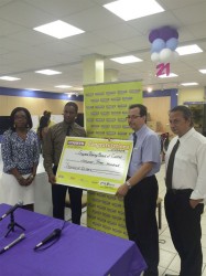 Courts’ (Unicomer Guyana Inc.) Pernell Cummings (left) hands over the sponsorship cheque to GBBC member Howard Cox in the presence of Courts’ PRO Roberta Ferguson and president of the GBBC, Peter Abdool.