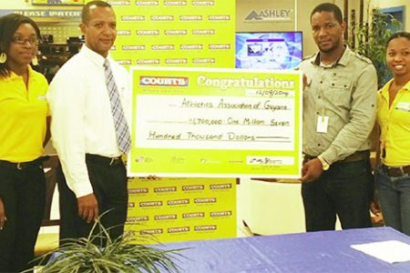 Courts’ Marketing Manager, Pernell Cummings hands over the sponsorship to president of the AAG, Aubrey Hutson following the launch of the 10km event yesterday at the furniture giant’s Main Street store.