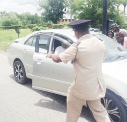 A policeman approaches the driver after he was returned to the scene of the accident