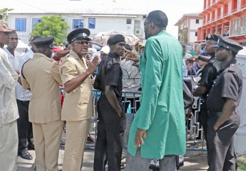 Standoff! PNC councillor Eon Andrews (third, right) has words with members of the City Constabulary over the barring of the City Hall gates yesterday (Photo by Arian Browne)