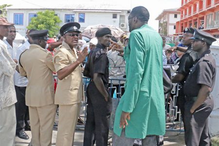 Standoff! PNC councillor Eon Andrews (third, right) has words with members of the City Constabulary over the barring of the City Hall gates yesterday (Photo by Arian Browne)