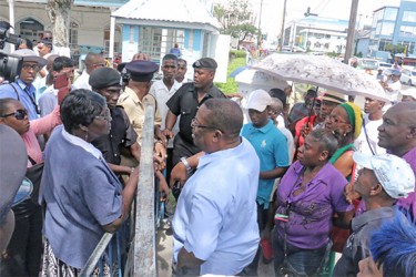 The barred gates being opened for a man to enter as supporters of the prayer meeting look on. (Photo by Arian Browne) 