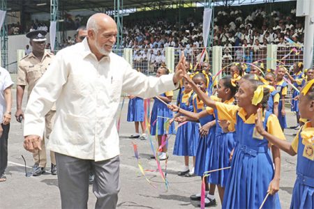 President Donald Ramotar greeting students from the West Ruimveldt Primary School on the National Park tarmac yesterday at the Education rally. (Arian Browne photo)
