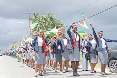 Cyril Potter College of Education teachers in training waving the National Flag as they participated in the Education march in the city yesterday. (Arian Browne photo) 