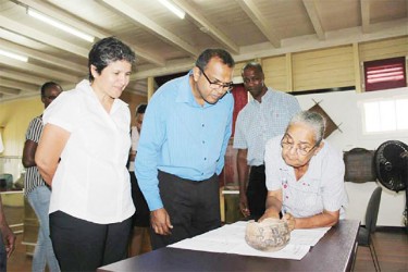 Former curator of the Walter Roth Museum Jenny Wishart indicating the Akawaio markings on the 2,000-year-old pot to Minister Frank Anthony, while Permanent Secretary Alfred King and Annette Arjoon-Martins look on. (Culture Ministry photo)  