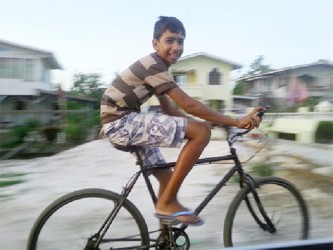 A child riding his bicycle gleefully along the access road 