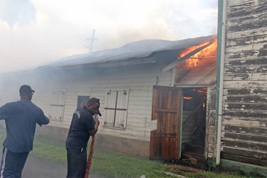 Firefighters trying to put out the flames which damaged the Guyana National Newspaper Limited’s bond  yesterday.  