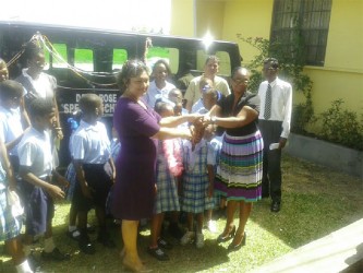 Minister of Education Priya Manickchand (left, front) handing over the keys to Headmistress Dionne McKenzie yesterday.