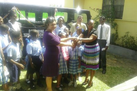 Minister of Education Priya Manickchand (left, front) handing over the keys to Headmistress Dionne McKenzie yesterday.