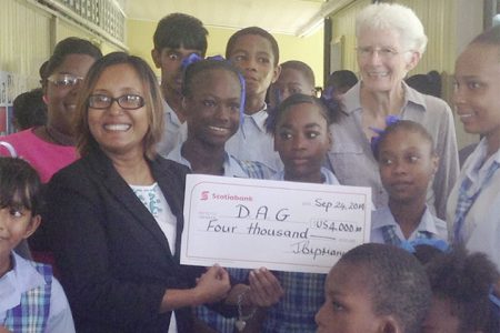 Manager of Scotiabank Jennifer Cipriani (left with cheque) presents the US$4,000 cheque to some deaf students and the President of the Deaf Association of Guyana (DAG) Sabine McIntosh.