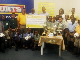 Troy Mendonca, Petra Organization Co-Director (fourth from left) collecting the sponsorship cheque from Courts Marketing Manager Pernell Cummings (sixth from left) while Assistant Chief Education Officer Marcel Hudson (centre) and representatives of Courts, Petra and the participating schools look on. 