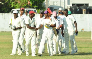 Devon Clements (left) and Kandasammy Surujnarine right are congratulated by Essequibo’s fielders after they completed the match. 