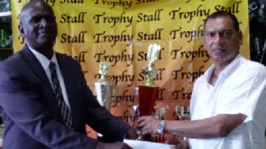 Trophy Stall’s Ramesh Sunich hands over trophies to golf club Public Relations Officer Guy Griffith (L). 