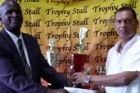 Trophy Stall’s Ramesh Sunich hands over trophies to golf club Public Relations Officer Guy Griffith (L).