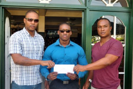 Carey Griffith (left) and Noel Lancaster (right) presenting monetary sponsorship to Mr. Guyana Kerwin Clarke yesterday. (Orlando Charles photo)
