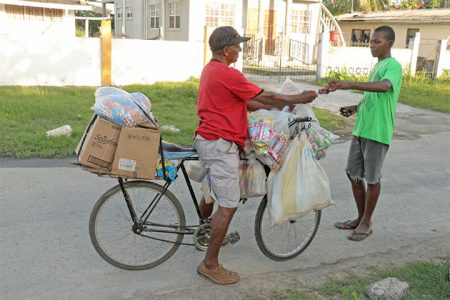 A mobile enterprise:  Mr Hardatt takes his business on the road with his bicycle to sell wholesale and retail to customers around East Ruimveldt, Georgetown. (Arian Browne photo)