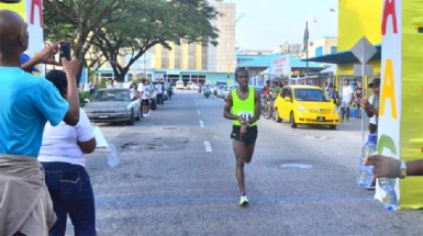 Cleveland Thomas cruising across the finish line to win the fourth annual Courts 10km road race yesterday. (Orlando Charles photo)