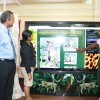 Administrator (ag) Ms Nadia Madho (centre) and student Rojeria McWatt try one of the touchscreens while Culture Minister Frank Anthony looks on. 