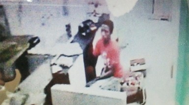 A grab from the video shows the suspect diving into the cupboard at Halema’s Fashions yesterday.