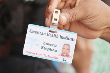A student displays a school identification for the American Health Care Institute.