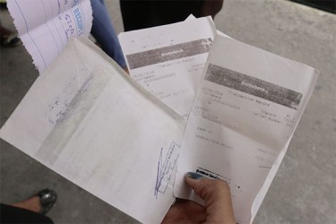 Students show some of the receipts for payment for courses at the school 