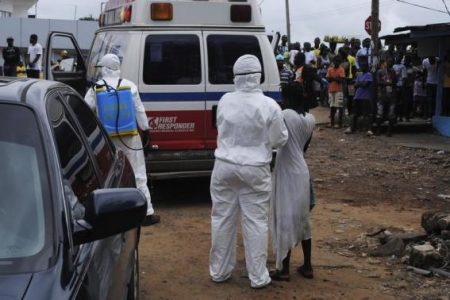 Health workers bring a woman suspected of having contracted Ebola virus to an ambulance in front of a crowd in Monrovia, Liberia, on September 15, 2014.
(Reuters/James Giahyue)
