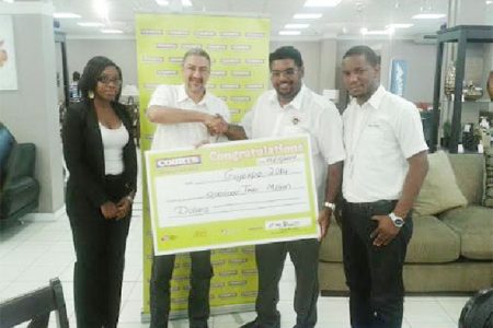 Minister of Tourism, Industry and Commerce, Irfaan Ali (second from right) receives the cheque for $2 million from Courts Country Manager Clyde de Hass (second from left) in the presence of Roberta Ferguson, Public Relations Officer (extreme left)  and Pernell Cummings,  Marketing Manager.