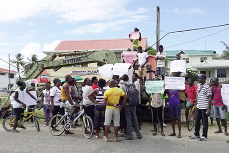 Residents of Plaisance hold signs in front of the Plaisance/Industry Neighbourhood Democratic Council (NDC) picketing what they charge is a land grab by the government through the Interim Management Committee and the newly appointed overseer.