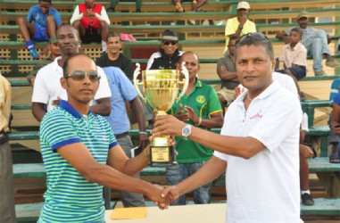 Demerara skipper Vishaul Singh receiving his winning trophy from GCB Secretary Anand Sanasie