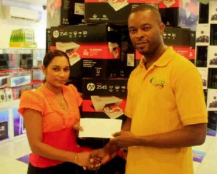 Carwyn Holland president of the Guyana Sambo Federation receives a sponsorship  cheque from Subrina Rampersaud.