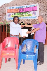 A representative of Aurora Gold Mines (left) hands over the chairs to St Cuthbert’s Mission Toshao Luke Simon