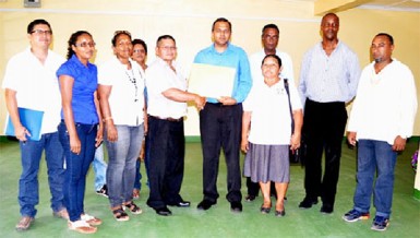 Minister of Culture, Youth and Sport, Dr Frank Anthony (fifth from right) presents grants for a ground enhancement project to Region Nine Chairman, Wilson Lorentio. Five villages are to benefit this year. 