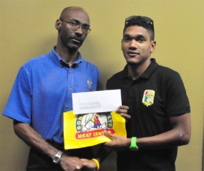 Bounty Farm’s accountant, Garfield Wiltshire (left) handing over the sponsorship cheque to Alanzo Greaves yesterday. (Orlando Charles photo) 