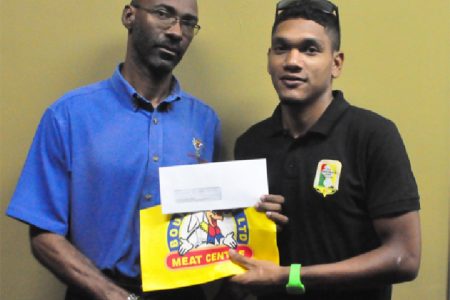 Bounty Farm’s accountant, Garfield Wiltshire (left) handing over the sponsorship cheque to Alanzo Greaves yesterday. (Orlando Charles photo)