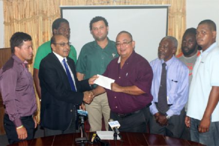 President of the GOA, K Juman Yassin (second from left) handing over the $3M dollar cheque to Peter Green. (Orlando Charles photo)
