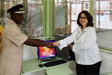 Rotary Club of Demerara President Gillian Mohhabir hand over the computers to Officer in Charge of the programme Gladwin Samuels.