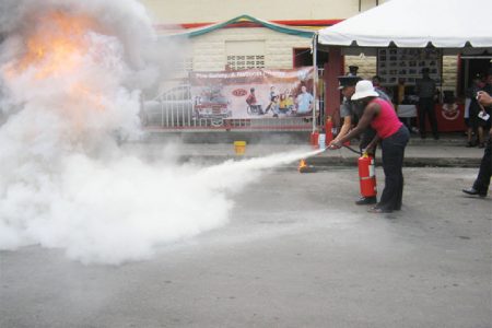  A member of the public being taught how to use a fire extinguisher.