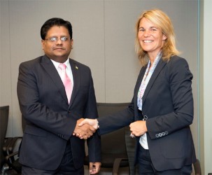 Minister of Finance Dr Ashni Singh shakes hands with Director of the Caribbean Country Management Unit of the World Bank Sophie Sirtaine after the signing. (Ministry of Finance photo)