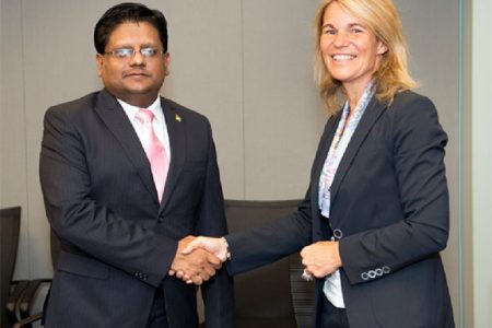 Minister of Finance Dr Ashni Singh shakes hands with Director of the Caribbean Country Management Unit of the World Bank Sophie Sirtaine after the signing. (Ministry of Finance photo)