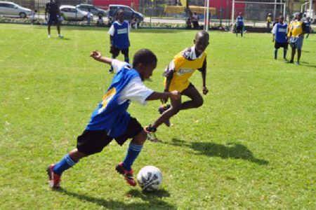 Tucville Primary’s Rayheem Marques (left) trying to evade his St. Gabriel Primary marker during his side’s 3-0 win

