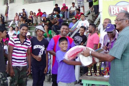 Director of Sport Neil Kumar (left) presents a quantity of sporting gear to a participant at the ‘Day of Interaction.’